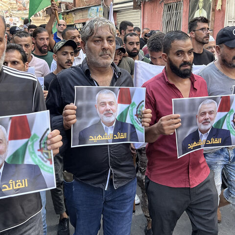 People carry pictures of slain Hamas leader Ismail Haniyeh during a march to condemn his killing, in the Palestinian refugee camp of Ain al-Hilweh, Sidon, Lebanon, July 31, 2024.